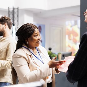 Semaine du Cerveau 2026 Une femme tient un flyer dans sa main. Elle discute avec un homme.