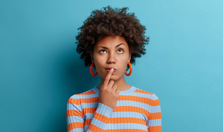 Une femme avec un doigt posé sur sa bouche